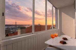 Ein Balkon mit Blick auf eine Brücke und Gebäude im Abendlicht.