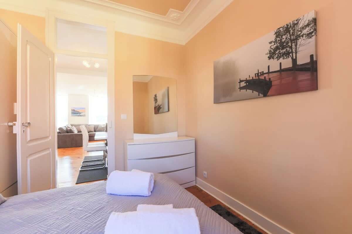 Ein Schlafzimmer mit einem Bett, einem Schminktisch, einem Spiegel und einem Bild an der Wand.
