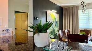 A hotel room with a dining area, a potted plant on the counter, and a sign with WiFi details. - Diamond-Convenient Spa bath condo with ADA access (Mt Pleasant)