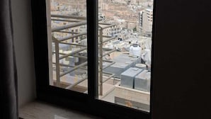 A window with a view of a cityscape, including buildings and a distant hill. - Saint Francis Hotel (Bethlehem)