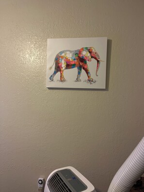 A wall with a framed artwork of an elephant. - Studio apartment across the street from the convention center (San Diego)
