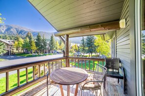 A wooden deck with a table and chairs, overlooking a street and mountains. - Pet Friendly 2+L/3BA W/ Views! Jacuzzi, W/D & BBQ (Mammoth Lakes)