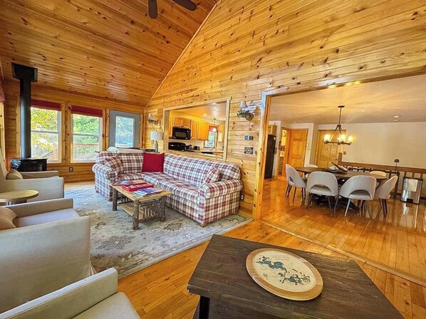 Un intérieur de chalet chaleureux comprenant un espace de vie, un coin repas et une cuisine.