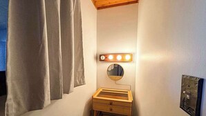 A small bathroom with a vanity, a mirror, and a light fixture. - Hilltop - Bouchard Shores Resort (Minocqua)