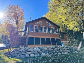 A modern two-story building with a wooden facade, large windows, and a stone foundation. - Hilltop - Bouchard Shores Resort (Minocqua)