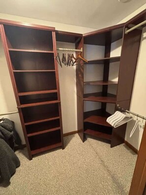 Ein begehbarer Kleiderschrank mit mehreren Regalen und Platz zum Aufhängen von Kleidung.