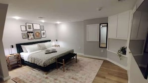 Una camera da letto con un letto, comodini, un tappeto e quadri appesi al muro.