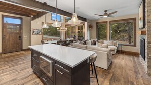 A spacious kitchen with a central island, wooden flooring, and large windows offering views of the outdoors. - Charming Ski Condo Near Keystone with Fireplace & Scenic Balcony (Keystone)