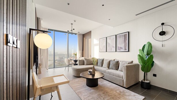 A modern living room with a sofa, coffee table, and a large potted plant.