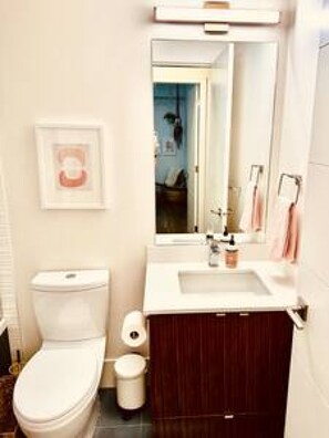 Ein Badezimmer mit Toilette, Waschbecken und Spiegel.