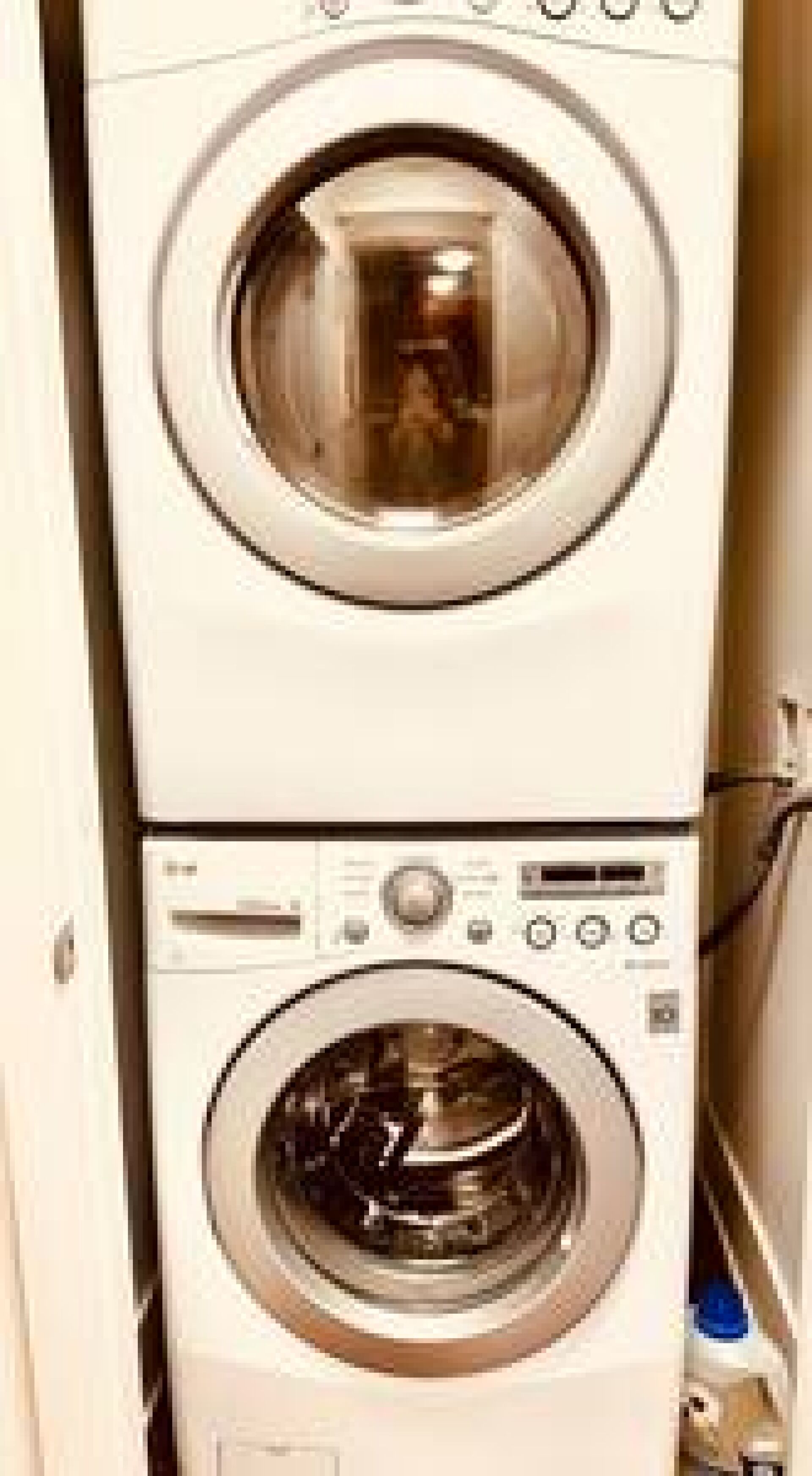Un appareil combiné lave-linge et sèche-linge, de type « empilable », doté de panneaux de commande.
