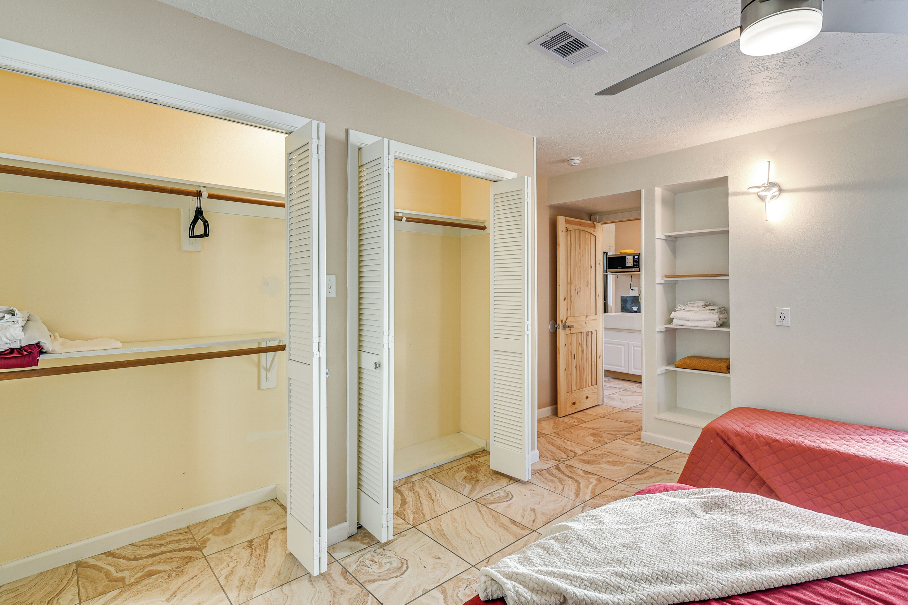 A bedroom with a bed, a closet, and a bathroom.
