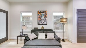 Une chambre à coucher avec un lit, une table de chevet, une lampe et un tableau au mur.