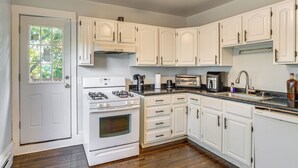 A kitchen with white cabinets, a stove, a microwave, and a dishwasher. - 2 Mi to Dtwn! Walkable Minneapolis Apt w/ Deck (Minneapolis)