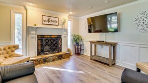A living room with a fireplace, a television mounted on the wall, and a sofa. - 2 Mi to Gardner Village: Family Gem w/ Fenced Yard (West Jordan)