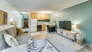A compact living space with a kitchenette, a sofa, a TV, and a lamp. - Easy Red River Ski Access! Outdoor Adventure Condo (Red River)