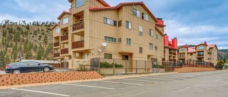 A multi-story hotel with a red roof, balconies, and a parking lot.