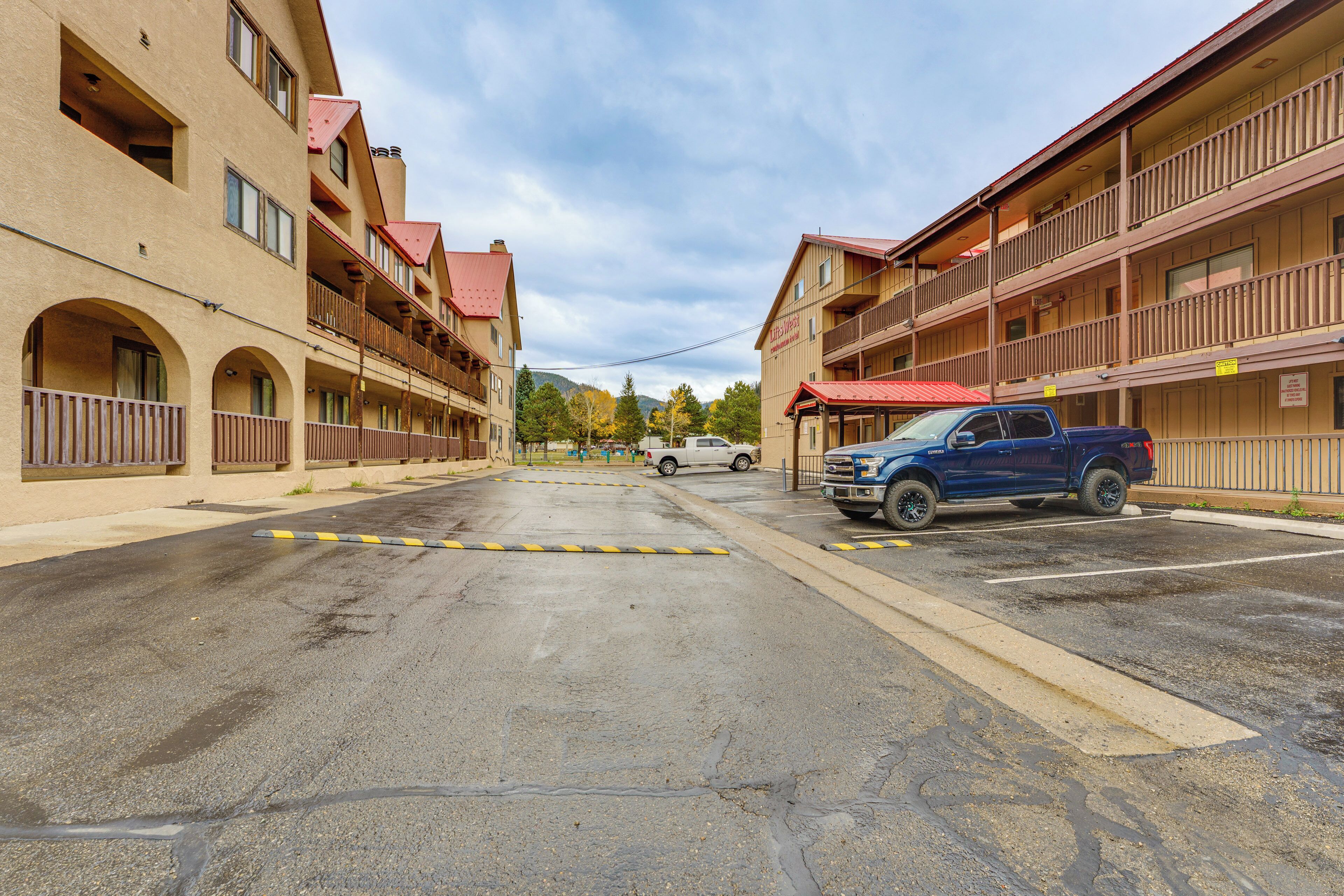 A multi-story hotel with balconies and a parking area.