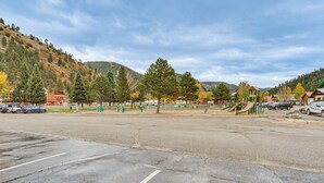 A parking lot with a playground and a building with a red sign. - Easy Red River Ski Access! Outdoor Adventure Condo (Red River)