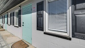 A row of doors with a 'No Parking' sign, a window with blinds, and a doormat on the ground. - Anglers Dream: Studio 2 Mi to 7 Sisters Springs! (Homosassa)