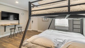 A bunk bed room with a desk and two stools, a TV, and a window with blinds. - Sleek Studio Bunk 2 Mi to Chassahowitzka River! (Homosassa)