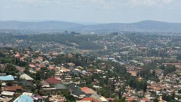 A densely populated urban area with numerous buildings and a hilly backdrop.