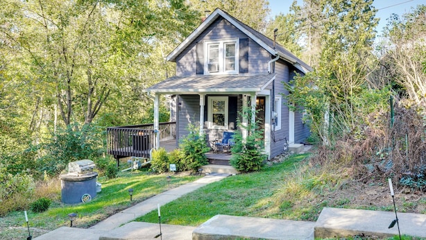 A two-story house with a porch, surrounded by trees and a grassy yard. - Little Woodland Home: Hidden Gem By Dtwn Bethlehem (Bethlehem)