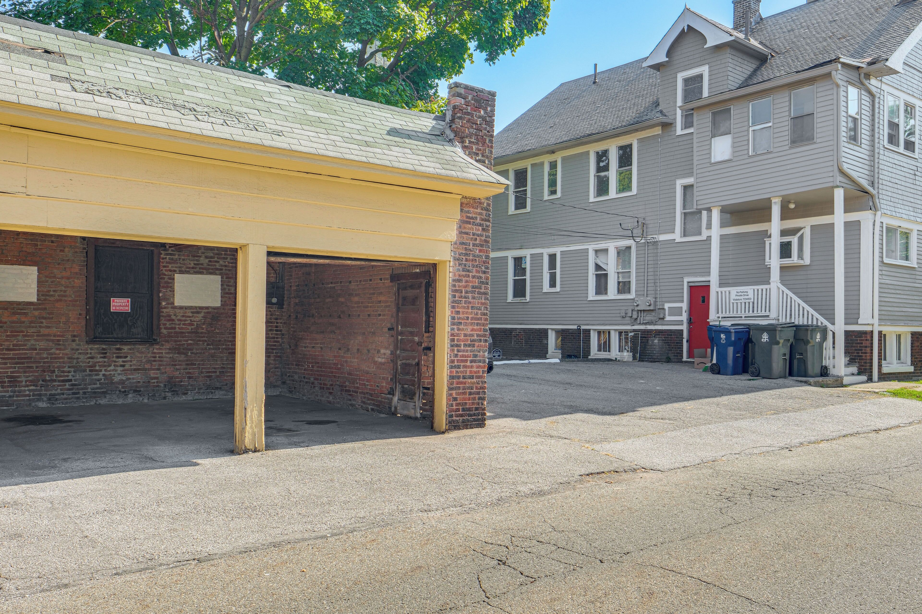 A building with a yellow awning, brick walls, and a red door.