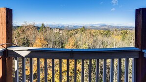 A wooden deck with a railing overlooking a mountainous landscape with autumn foliage. - Fire Pit & Peak Views: Gold Camp Area Cabin (Cripple Creek)