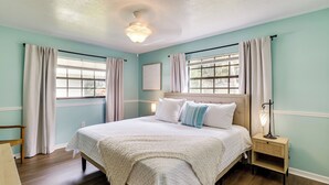 A bedroom with a bed, bedside table, and a nightstand. - Bring Your Boat! Canal-front Tavares Home w/ Dock (Tavares)
