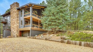A modern two-story house with a stone chimney, a balcony, and a gravel driveway. - Luxury Home w/ Hot Tub & Mtn Views in Angel Fire! (Angel Fire)