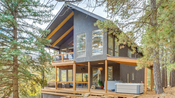 A modern two-story house with large windows, a balcony, and a deck area. - Luxury Home w/ Hot Tub & Mtn Views in Angel Fire! (Angel Fire)