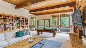 A spacious living room with a pool table, a sofa, a bookshelf, and a fireplace. - Luxury Home w/ Hot Tub & Mtn Views in Angel Fire! (Angel Fire)