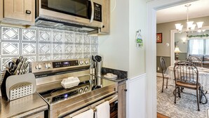 A kitchen with stainless steel appliances, a patterned backsplash, and a dining area with a table and chairs. - 2 Mi to Mohegan Sun & Dtwn: Home in Norwich (Norwich)