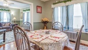 A dining area with a table set for four, surrounded by chairs, a chandelier, and a window with curtains. - 2 Mi to Mohegan Sun & Dtwn: Home in Norwich (Norwich)