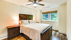 Un dormitorio con cama, mesita de noche y ventilador de techo.