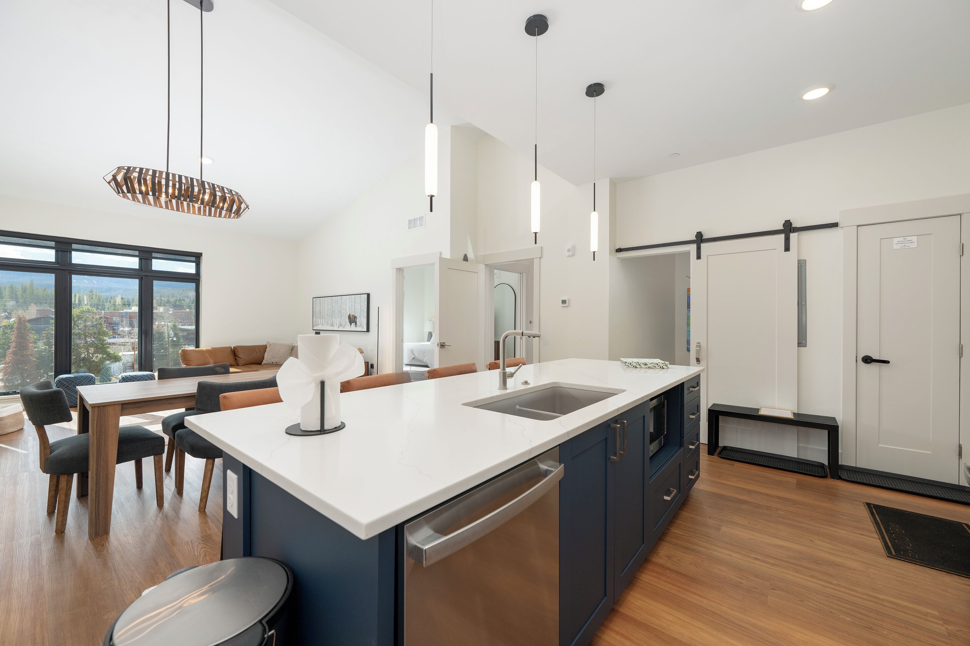 A modern kitchen with a large island, built-in appliances, and a dining area with a view.