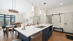 Una cucina moderna con una grande isola, elettrodomestici integrati e un'area pranzo con vista.