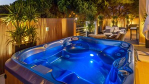 Ein Whirlpool mit Holzzaun und Pflanzen im Hintergrund.