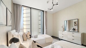 A modern hotel room with a large bed, a bedside table, a mirror, and a view of the city.