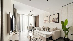 A modern living room with a sofa, coffee table, and dining area.