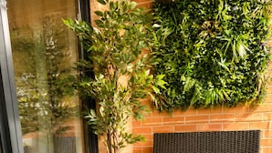 A wicker outdoor seating area with a table, chairs, a potted plant, and a basket. - PrivateTerrace Opposite PiccadillyLine • 20min SOHO, Oxford Street & Sightseeing (Uxbridge)
