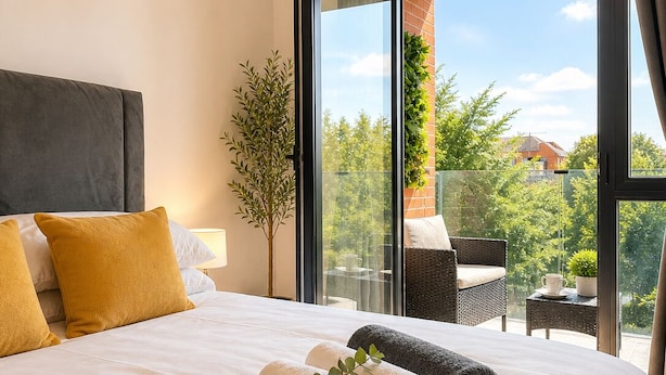 A hotel room with a large bed, a potted plant, and a view of the outdoors. - PrivateTerrace Opposite PiccadillyLine • 20min SOHO, Oxford Street & Sightseeing (Uxbridge)