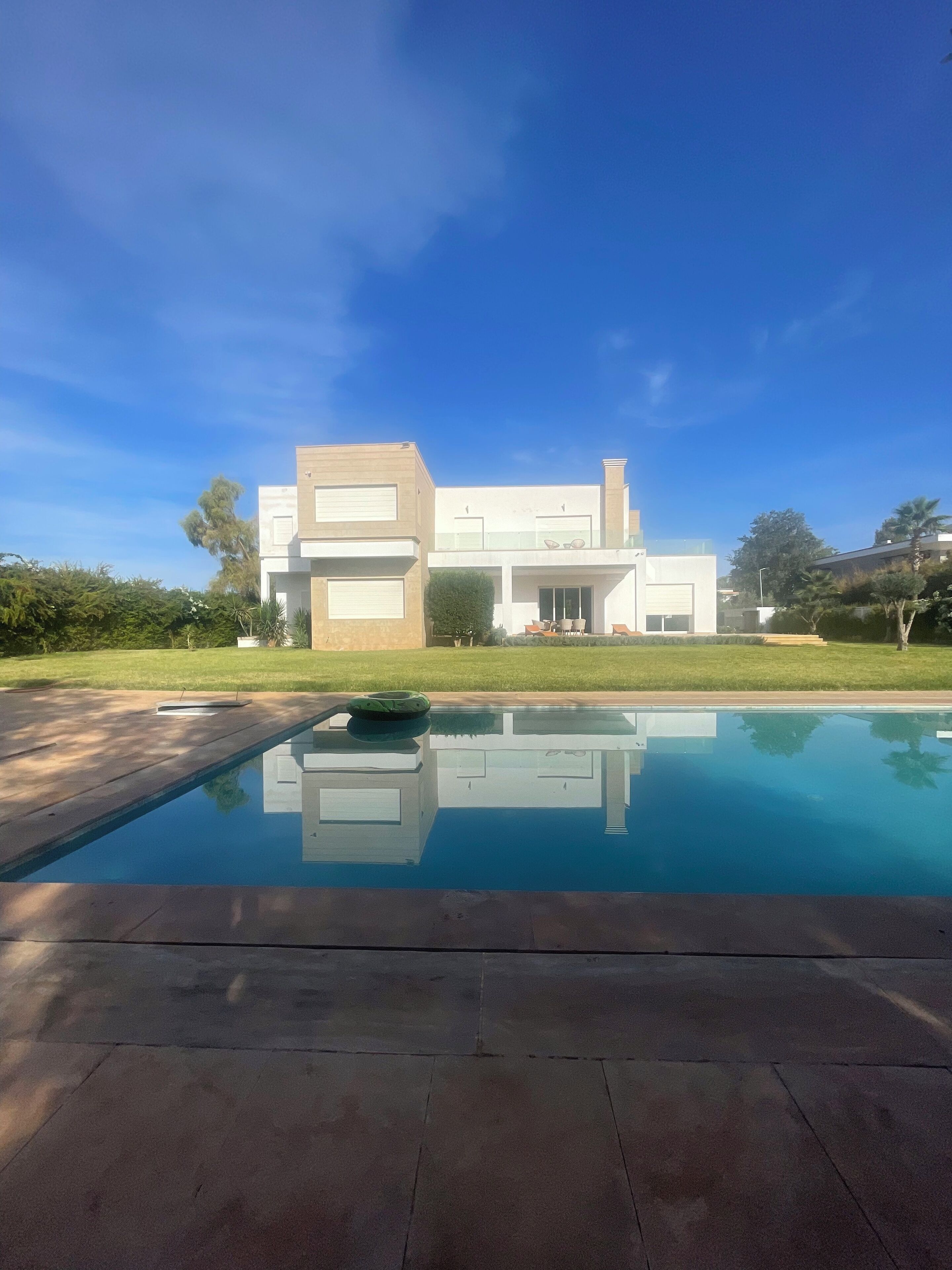 A modern house with a swimming pool in front.