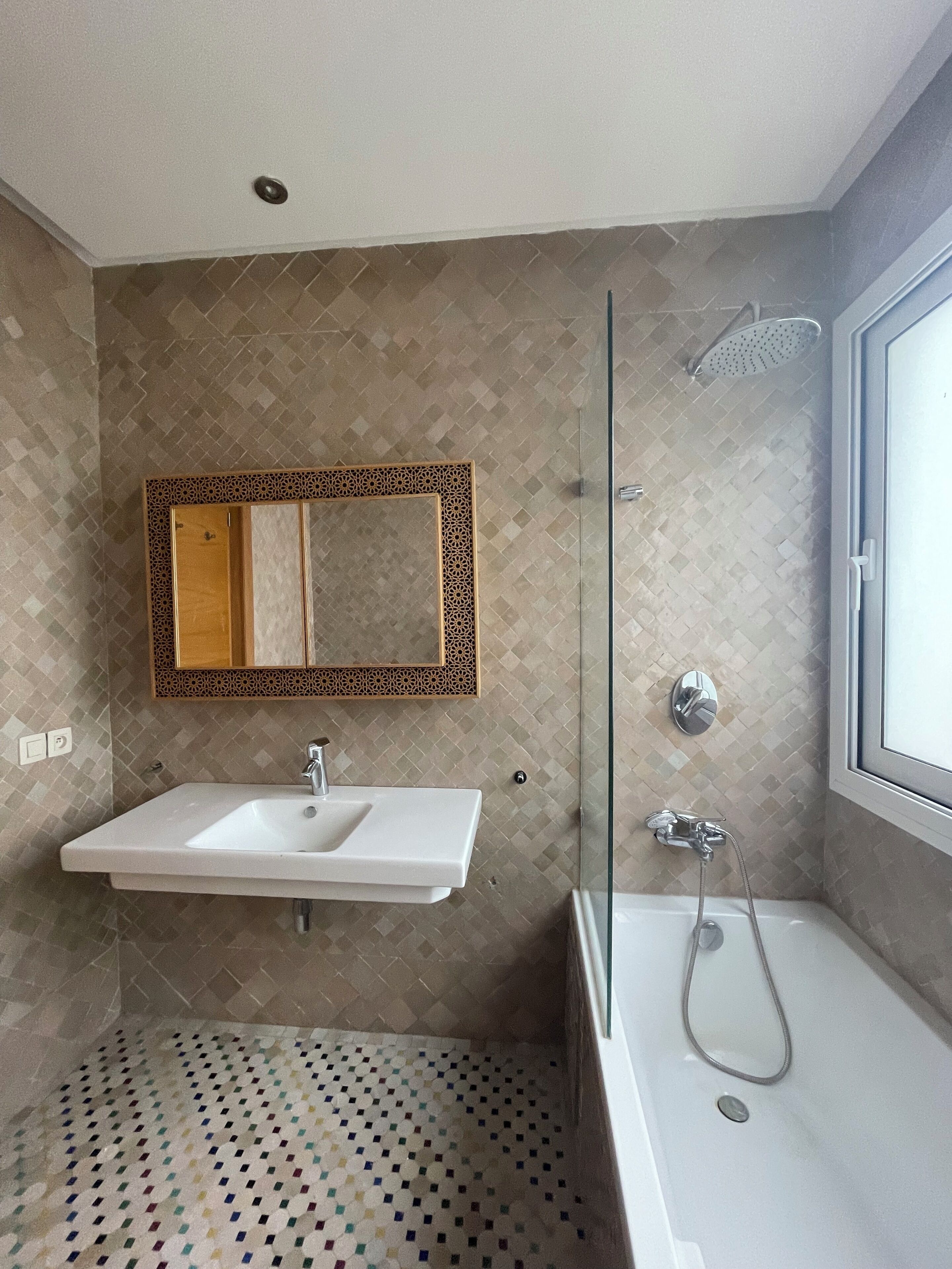 A modern bathroom with a freestanding bathtub, a sink with a mirror above it, and a shower with a glass door.