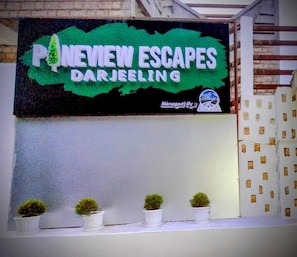 A sign for 'Pineview Escapes Darjeeling' with a green background and white text. - PINEVIEW ESCAPES (Darjeeling)