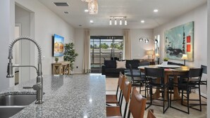 A modern kitchen with granite countertops, a stainless steel sink, and a unique faucet. - Cinderella’s Castle Retreat, Private Pool, Pokémon Room, Minutes to Disney! (Four Corners)