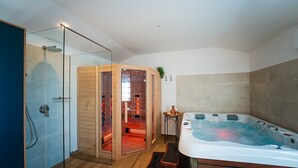 Ein modernes Badezimmer mit Duschkabine aus Glas, Sauna und Whirlpool.