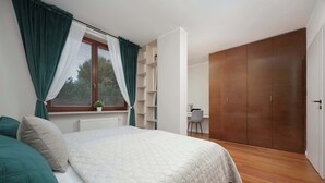 Quarto com cama, escrivaninha e guarda-roupa.