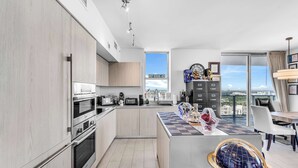 Una cucina moderna con elettrodomestici integrati, zona pranzo con vista e un'ampia finestra.